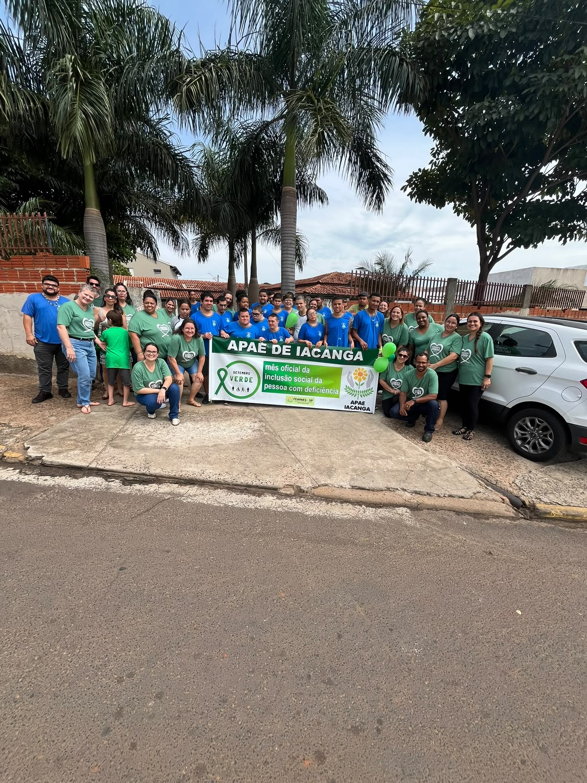 Equipe e participantes da APAE de Iacanga com faixa do Setembro Verde, mês oficial da inclusão social da pessoa com deficiência